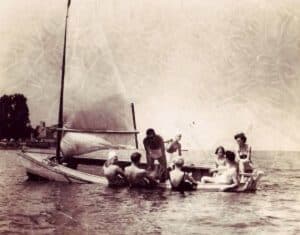 A group of people enjoying a day on the water with sailboats.