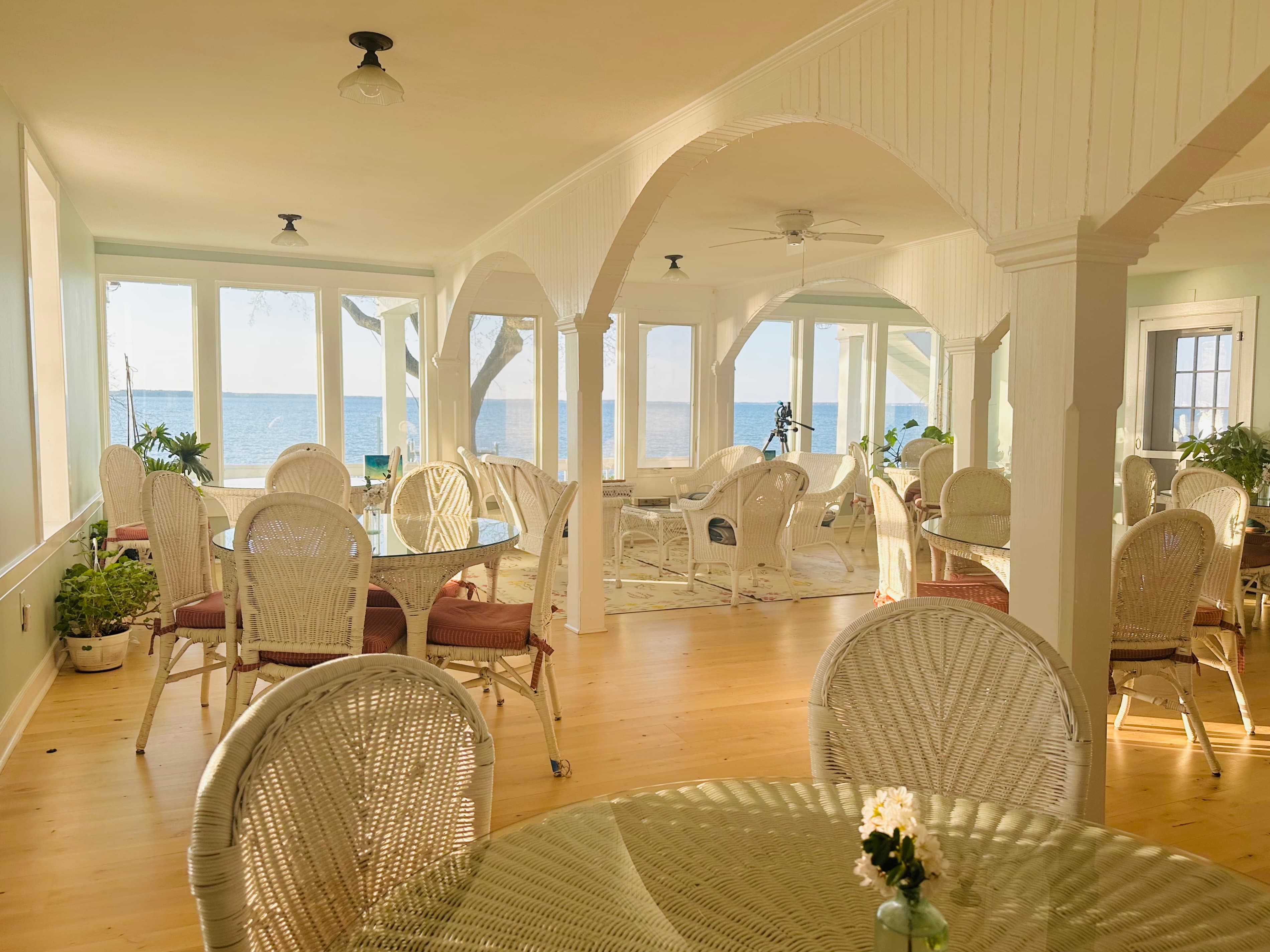 Bright, airy dining area with wicker furniture and ocean views.