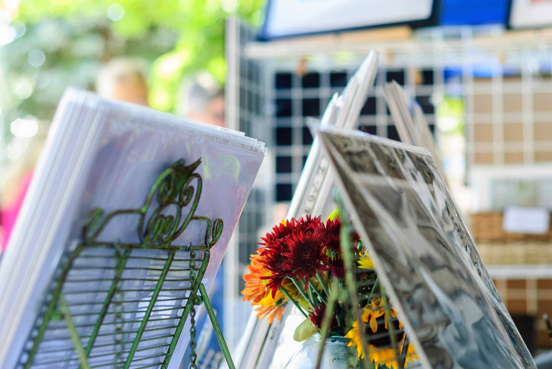 A display of greeting cards and fresh flowers at an outdoor market. A display of greeting cards and fresh flowers at an outdoor market.