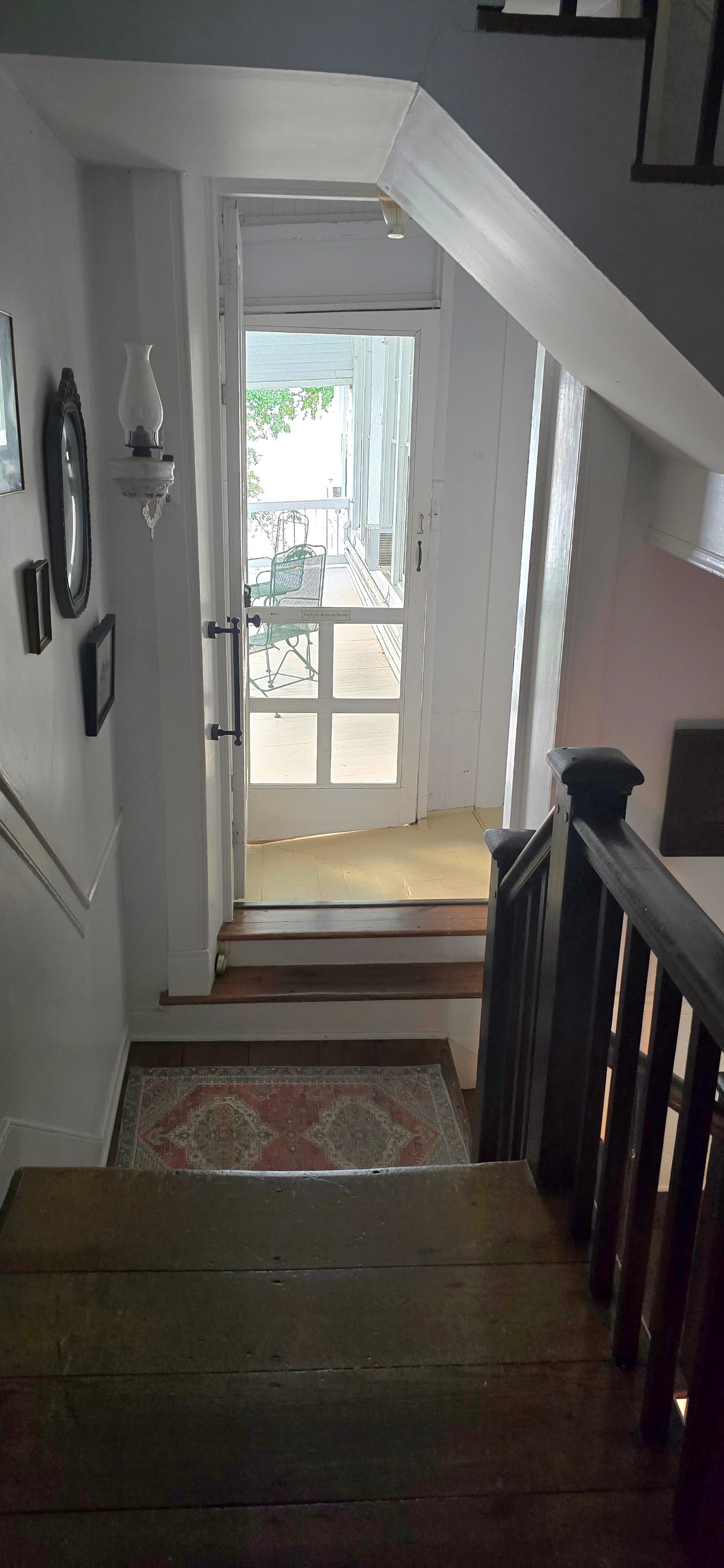 Stairs lead down to an open door with a view of an outdoor patio.
